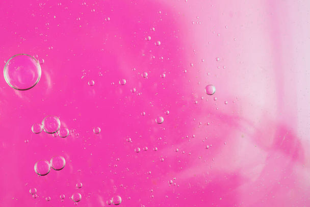 gotas de óleo na água em um contexto rosa - Foto, Imagem