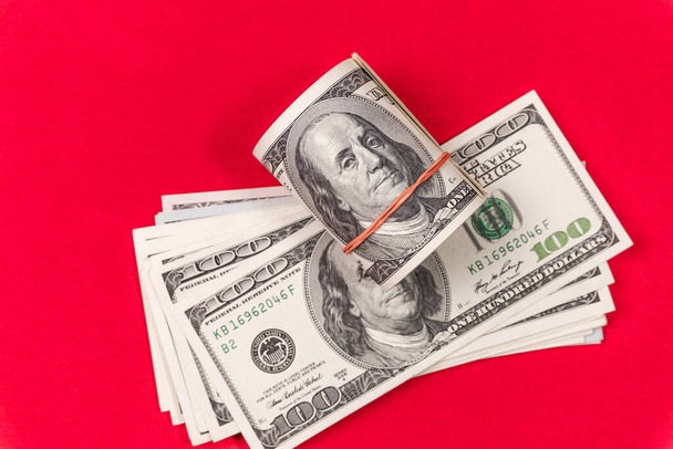Roll of american dollars on a red background. Financial concept. - Фото, зображення