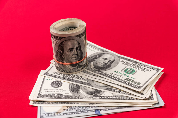 Roll of american dollars on a red background. Financial concept. - Φωτογραφία, εικόνα