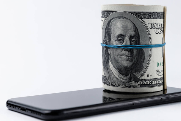 Roll of american dollars and smartphone. Mobile payment concept. - Φωτογραφία, εικόνα