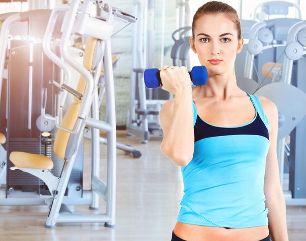 Sporty female doing physical exercise in gym - Foto, Imagem