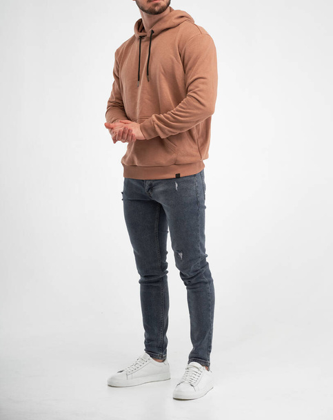 man wears beige hoodie. bearded young guy stands in khaki colored sweatshirt with hood. isolated catalogue shooting - 写真・画像
