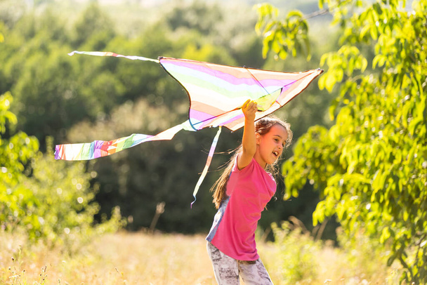 Little girl flying a kite running outdoor with a kite - Photo, Image