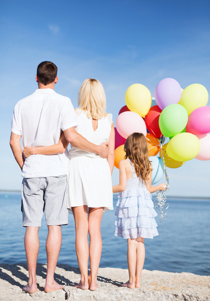 Happy family at the seaside with bunch of balloons - Foto, Imagen
