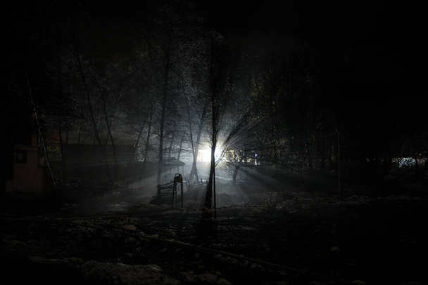ビルやフェンス霧のランプで覆われた夜の通りの田舎道。またはアゼルバイジャンの山間の村で神秘的な夜。長時間露光 - 写真・画像