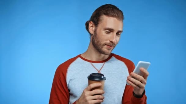 szczęśliwy człowiek z kawy, aby przejść wiadomości na smartfonie odizolowany na niebiesko - Materiał filmowy, wideo