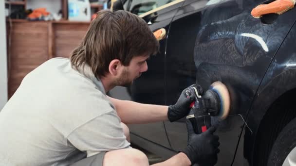 Détail de voiture - mains avec polisseuse orbitale dans l'atelier de réparation automobile - Séquence, vidéo