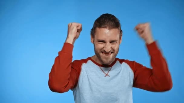 ενθουσιασμένος άνθρωπος δείχνει την επιτυχία χειρονομία απομονώνονται σε μπλε - Πλάνα, βίντεο