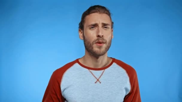 fiatal férfi gesztikulál, miközben beszél elszigetelt kék - Felvétel, videó