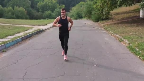 Runner training marathon in zomerpark luchtfoto. Jogging man oefeningen uithoudingsvermogen buiten. Energie jogger lopen in het stadspark. Fitness sporter training cardio. Knappe loper genieten van gezondheid levensstijl - Video