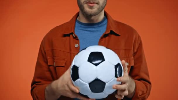 vista recortada del aficionado al fútbol emocionado mostrando gesto de victoria aislado en naranja - Metraje, vídeo