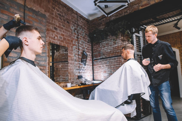 Os cabeleireiros cortaram os clientes na barbearia. Conceito de publicidade e barbearia - Foto, Imagem