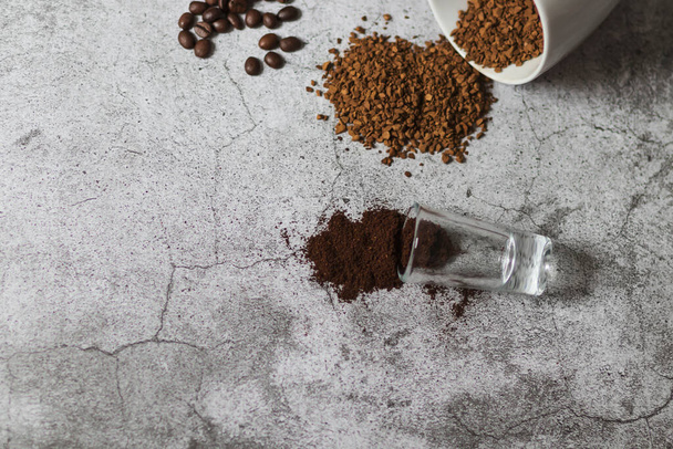 Растворимый кофе, кофейные зерна и молотый кофе. Все это на сером фоне. - Фото, изображение