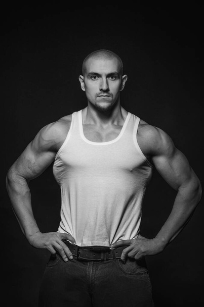 Sporty guy posing in the Studio on the background. Sports, beauty, black and white photography - Foto, afbeelding