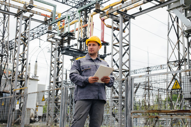The energy engineer inspects the equipment of the substation. Power engineering. Industry - Foto, Imagen