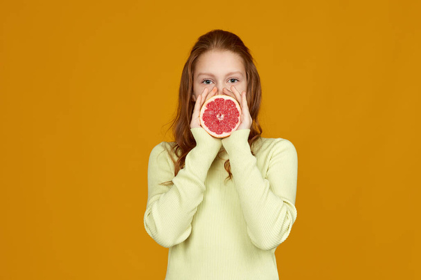 cute little child girl holding fresh juicy grapefruit - Foto, immagini