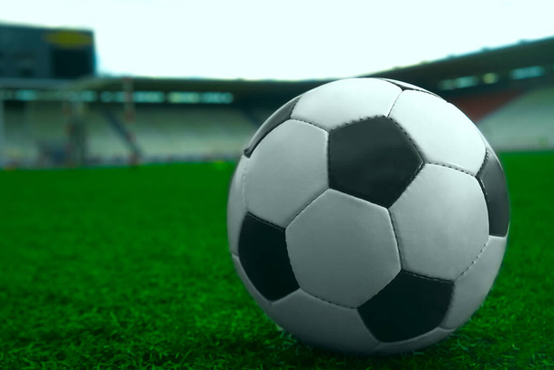 white and black soccer ball on green grass and stadium background. sports betting idea - Φωτογραφία, εικόνα