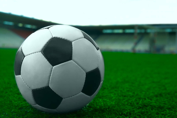 white and black soccer ball on green grass and stadium background. sports betting idea - Valokuva, kuva