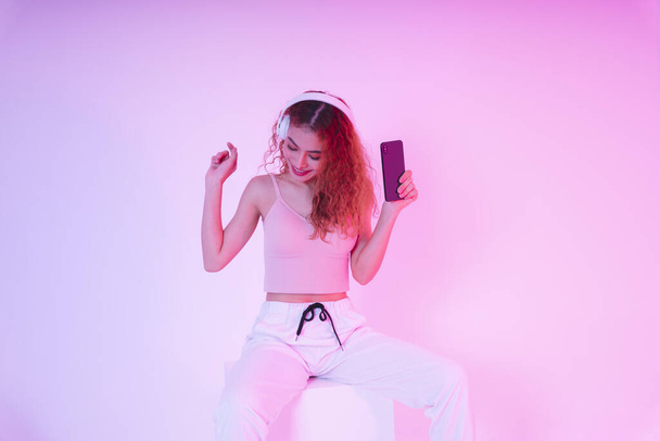 Young asian woman curly hair listen to music with headphone and dance. Streaming platform concept. - Photo, Image