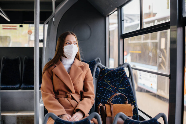 A young girl in a mask uses public transport alone, during a pandemic. Protection and prevention covid 19 - Фото, зображення
