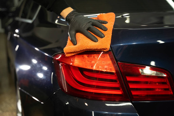 Mestre detalhada limpa o corpo do carro com microfibra. Conceito de remoção automática - Foto, Imagem