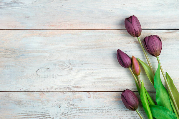 Boeket met tulpen op een lichte houten ondergrond. - Foto, afbeelding