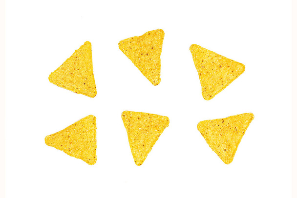Słony chrupiący i chrupiący trójkąt meksykańskie nachos kukurydziane izolowane na białym tle. - Zdjęcie, obraz