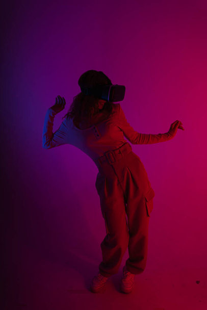 ハッピー女性はネオンライトの背景に仮想現実VRゴーグルを着用.  - 写真・画像