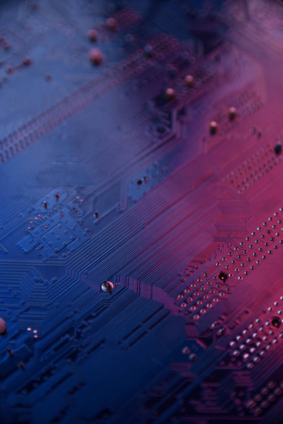 Κοντινό πλάνο του πίνακα κυκλωμάτων υπολογιστών σε μπλε και κόκκινο lihgts. - Φωτογραφία, εικόνα