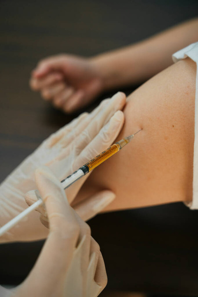El médico ayuda a las personas infectadas por el virus covid-19 mediante una vacuna inyectable en la pierna. - Foto, Imagen