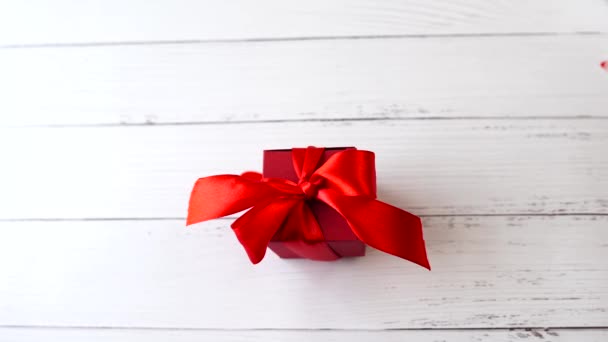 coeurs volent sur la Valentines boîte cadeau rouge sur table en bois blanc - Séquence, vidéo