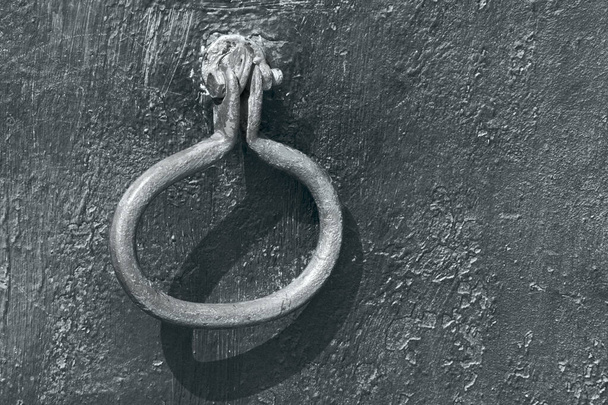 Een roestige ijzeren grendel hangt aan een oude deur. Zwart-wit foto. Retrostijl. - Foto, afbeelding