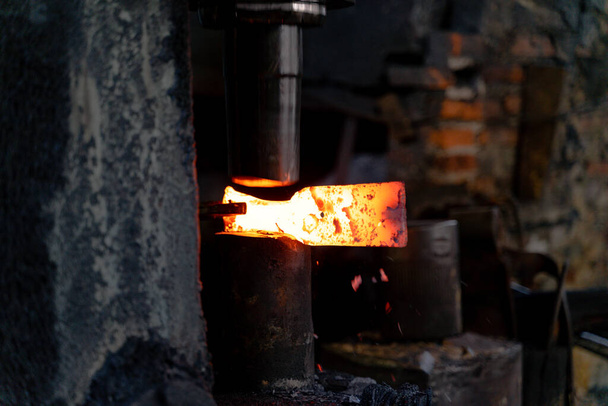 El herrero está forjando hierro muy caliente para hacer varias herramientas. - Foto, Imagen