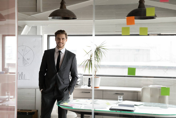 Portrait of successful young Caucasian businessman in office - Фото, зображення