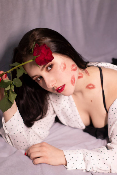 szexi barna nő csókokkal, rúzzsal az arcán és a nyakán, vörös rózsával. barátnő, randi, felvilágosítás. leszbikus meleg. - Igen, uram. másolás helye - Fotó, kép