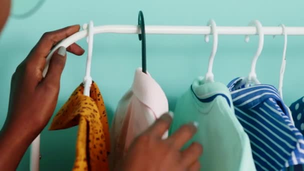 Femme noire est à la recherche de vêtements d'été sur le rack - Séquence, vidéo
