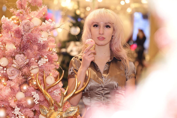 blond woman with ice cream close up portrait with Christmas pink tree - Photo, Image