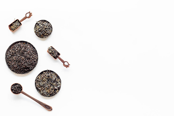 Set of dried tea leaves in bowls and spoons. Tea concept. Top view - Photo, Image