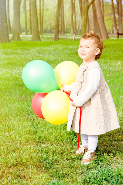 Child holding colorful balloons - Foto, Bild