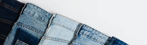 diagonal row of different jeans on white background, top view, banner - Φωτογραφία, εικόνα