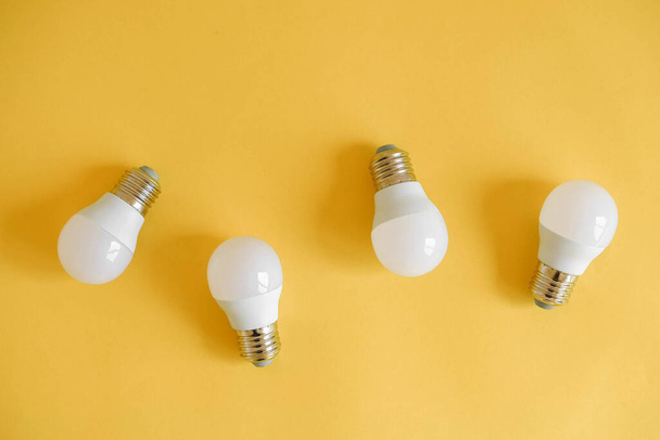 LED light bulbs on yellow background. Top view. Copy, empty space for text. - Фото, изображение