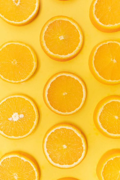 A top view of orange slices on yellow back - Фото, изображение