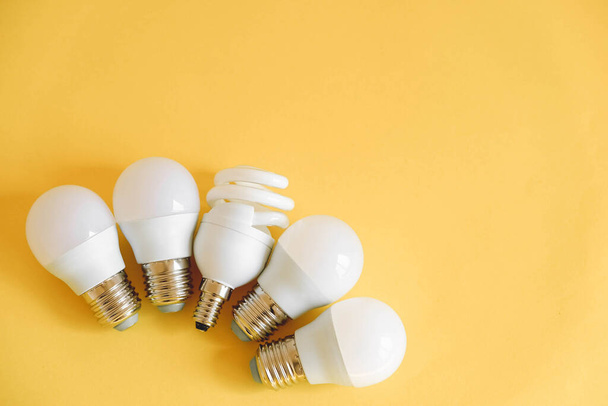 LED light bulbs on yellow background. Top view. Copy, empty space for text. - Фото, зображення