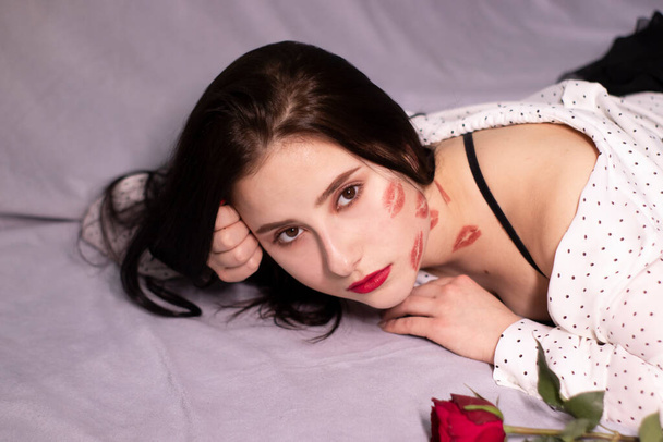 seksikäs brunette nainen suukkoja, huulipuna jälkiä hänen kasvonsa ja kaulansa, punainen ruusu. Tyttöystävä, päivämäärä, relashionship. Lesbo homo. Igbt. kopioi tila - Valokuva, kuva
