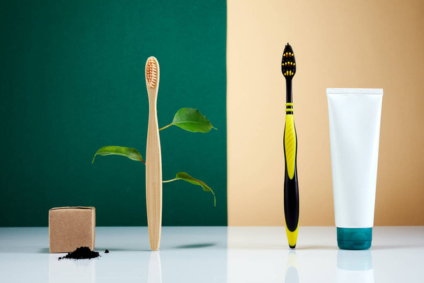 Zero waste, Eco-friendly creative concept. Wooden bamboo toothbrush with leaves VS plastic brush. Natural organic bathroom beauty product. Life without plastic. - Foto, Imagen