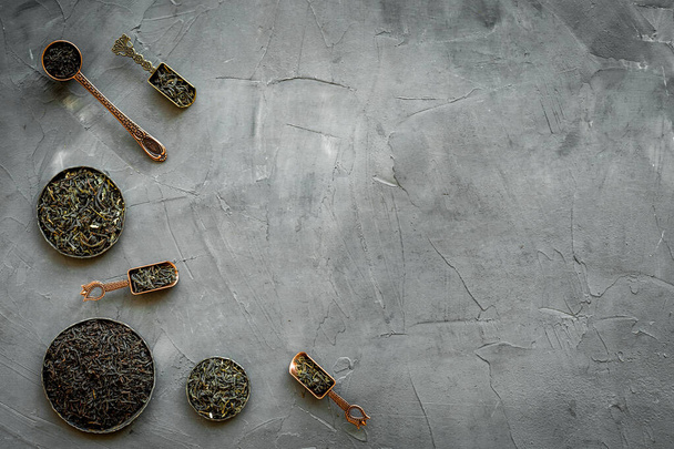 Set of dried tea leaves in bowls and spoons. Tea concept. Top view - Foto, afbeelding