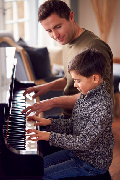 Young Boy Learning To Play Piano Having Lesson From Male Teacher - Foto, Bild