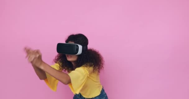 curly woman in vr headset gaming and laughing isolated on pink - Footage, Video