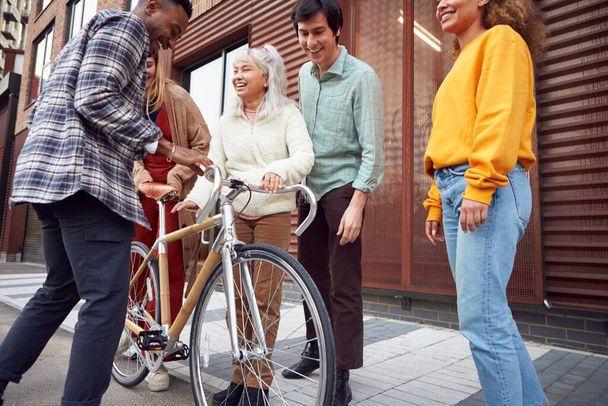 Group Of Multi-Cultural Friends Walking On City Street With Sustainable Bamboo Bicycle - Foto, Imagen