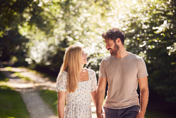 Loving Couple Walking Holding Hands Along Countryside Path In Summer Together - Foto, Bild